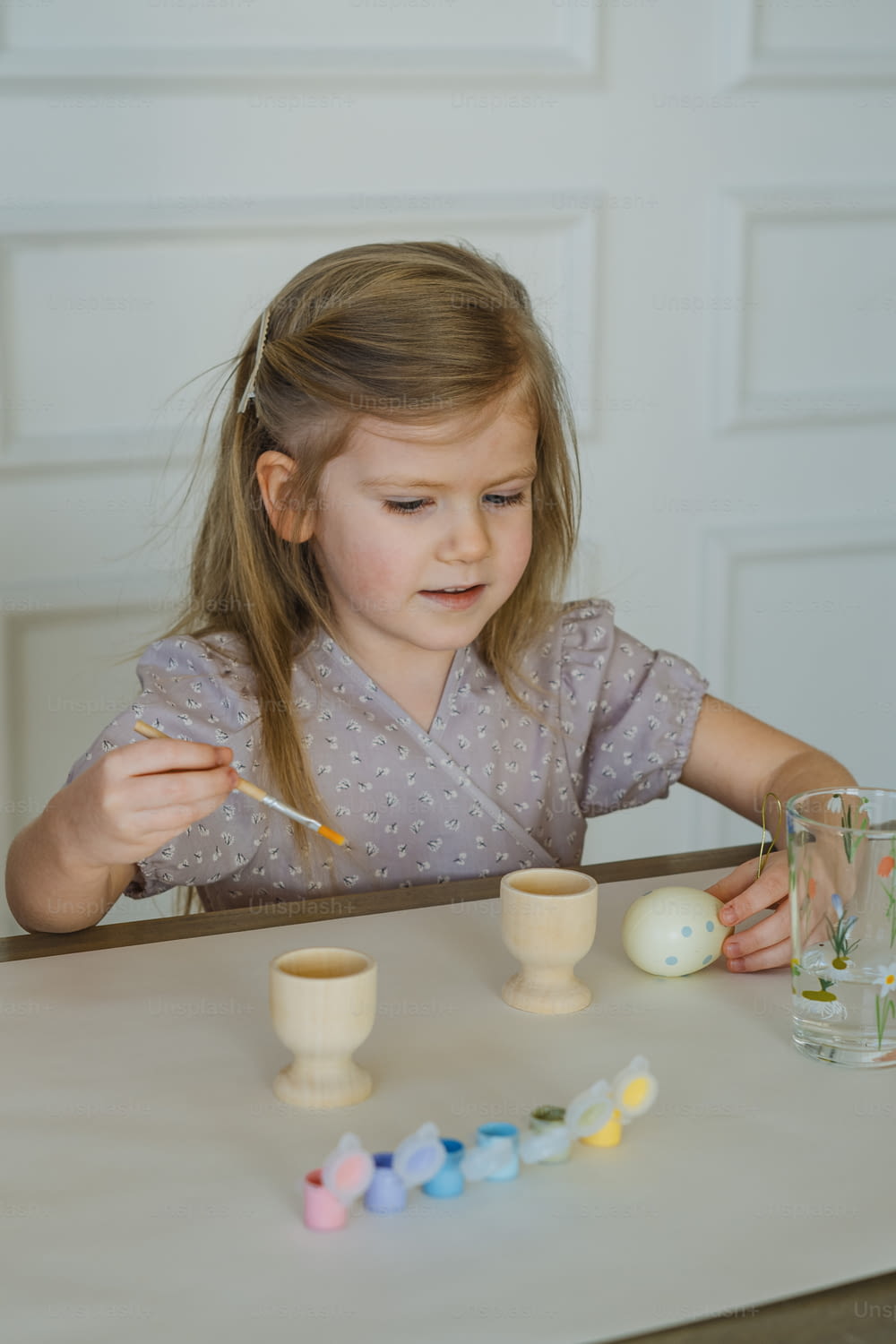 Una niña sentada en una mesa con una cuchara en la mano