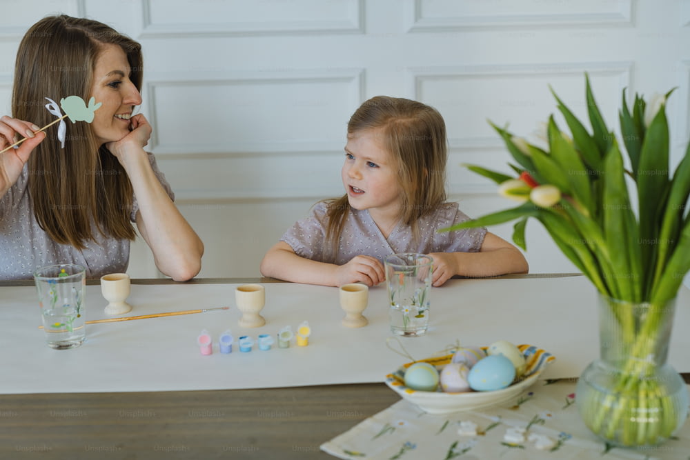 Eine Frau und ein kleines Mädchen sitzen an einem Tisch