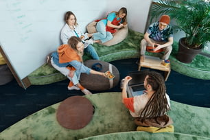Un gruppo di persone sedute su sacchi di fagioli in una stanza