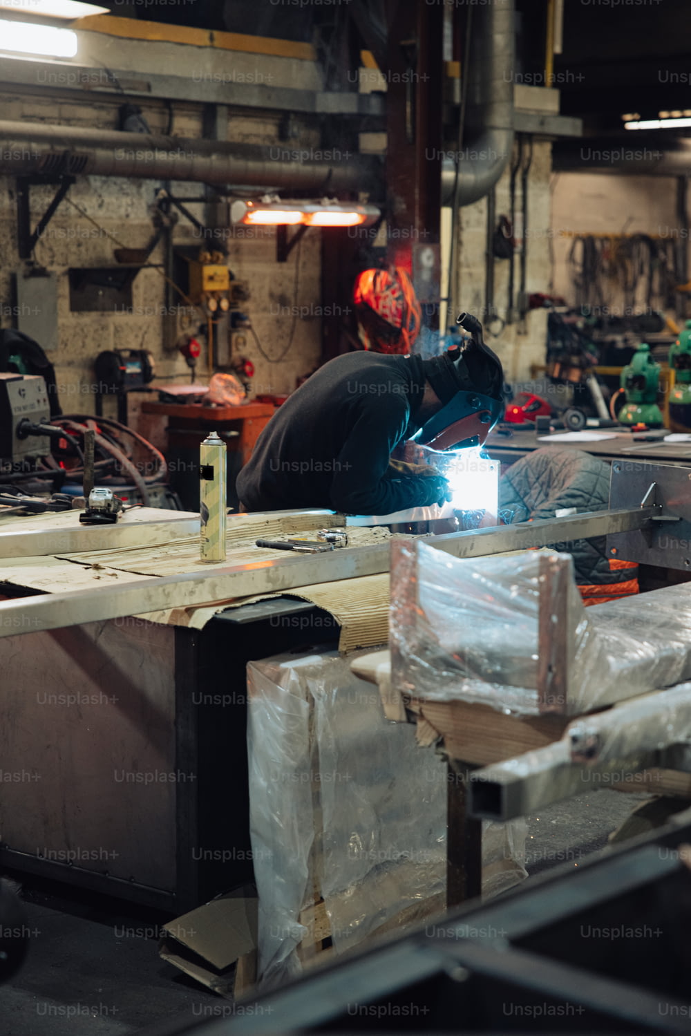 a man working on a piece of metal in a shop