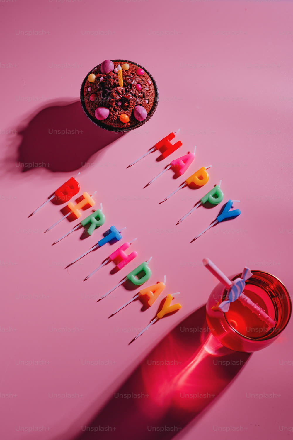 a birthday cake with candles on a pink table