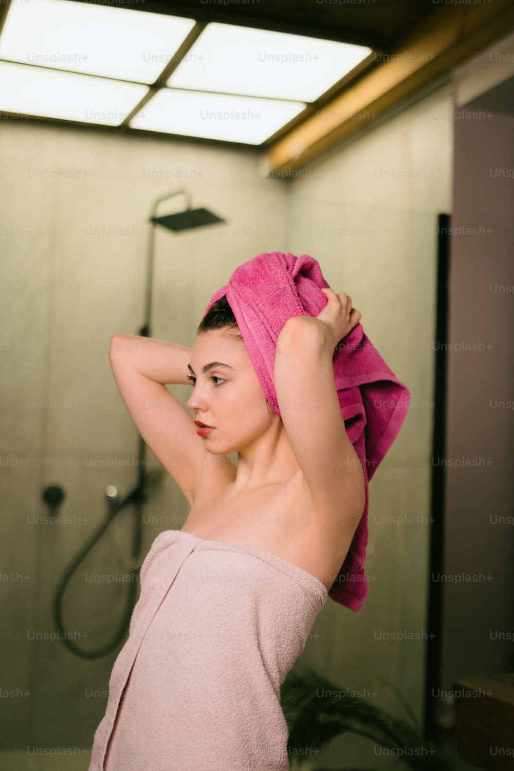 a woman in a towel is standing in front of a shower