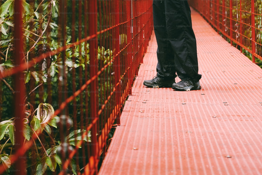 Una persona che cammina attraverso un ponte rosso sull'acqua