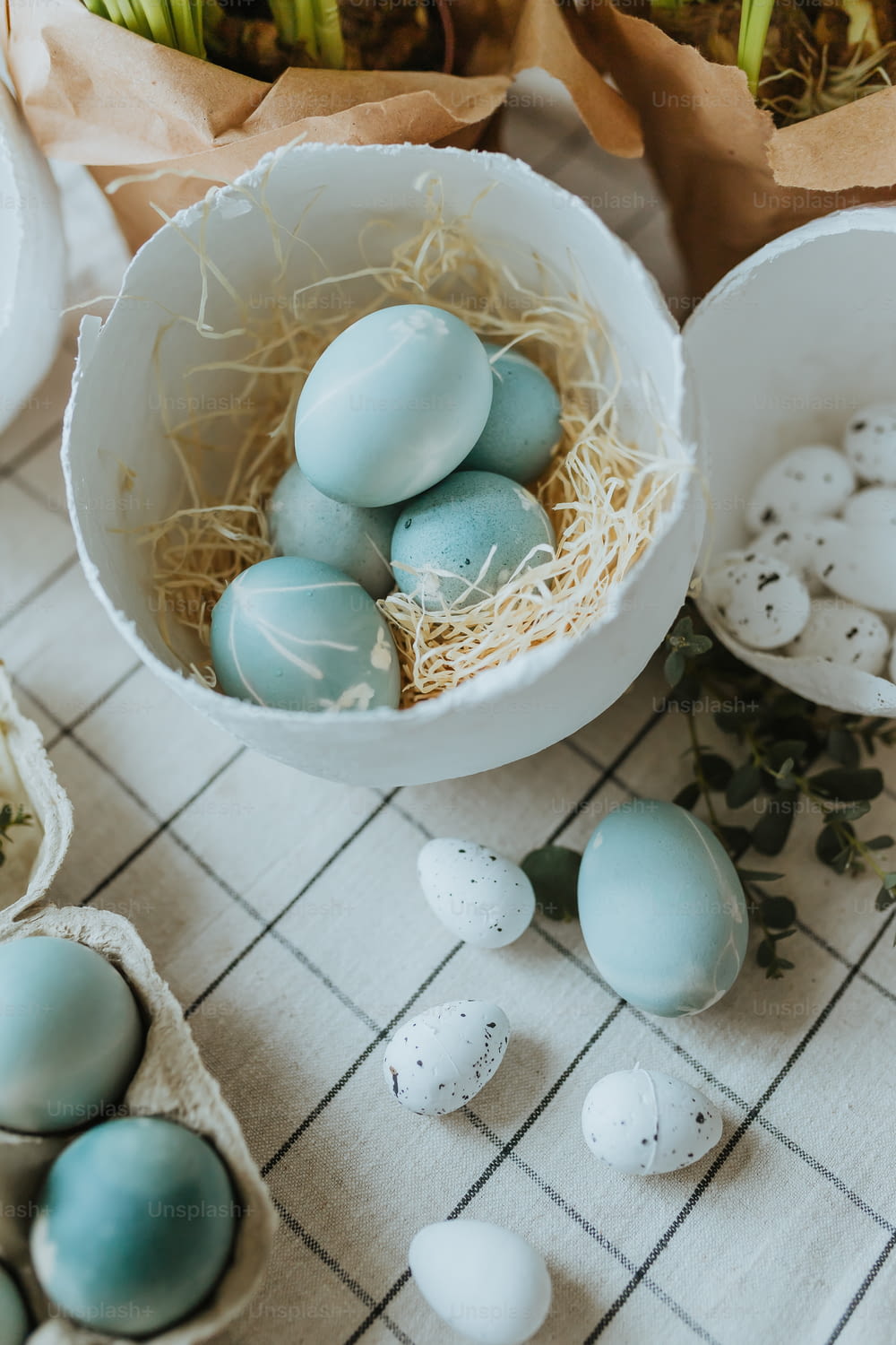 a bowl filled with blue and white eggs on top of a table