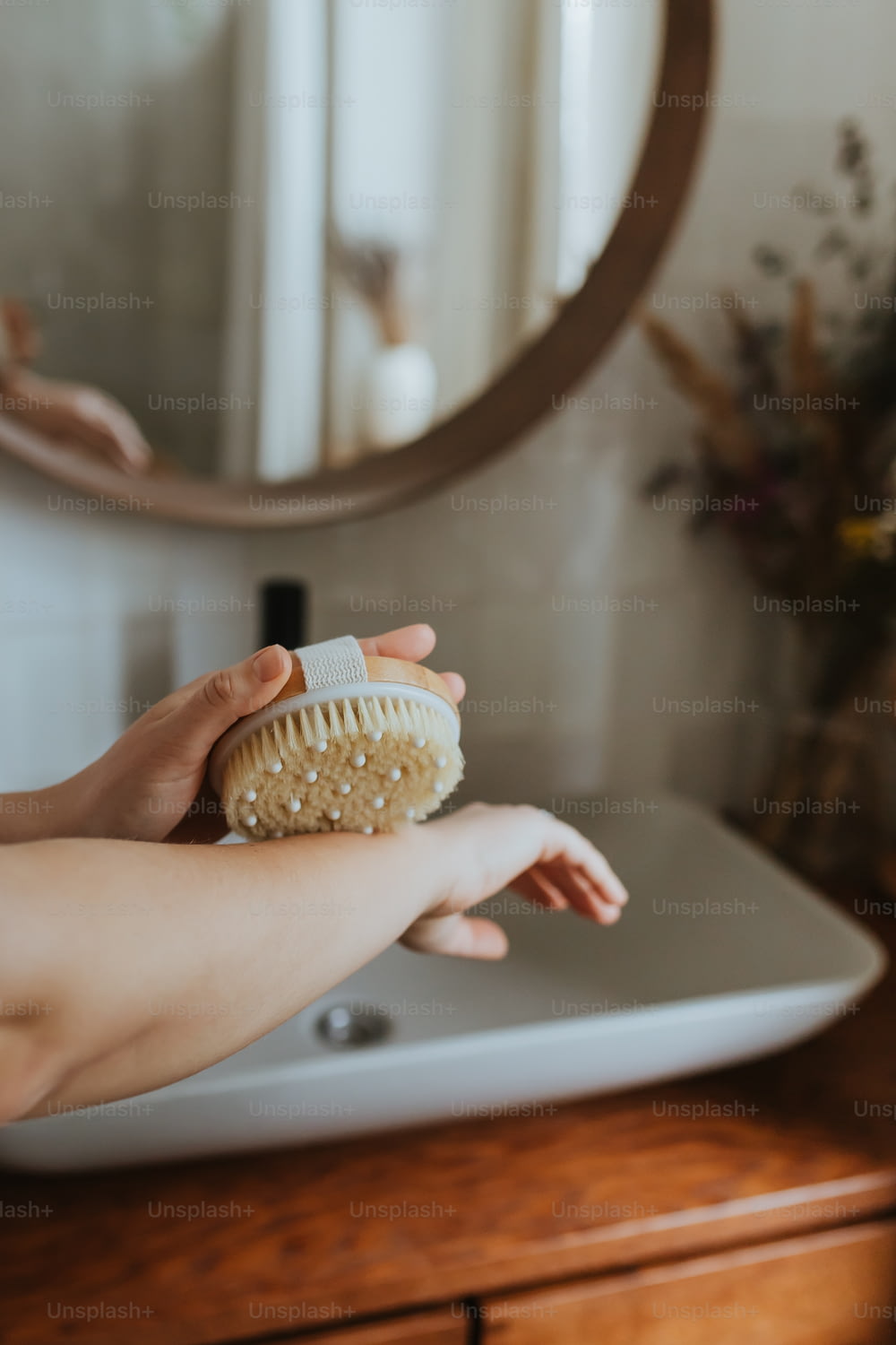 a woman is holding a brush in front of a mirror