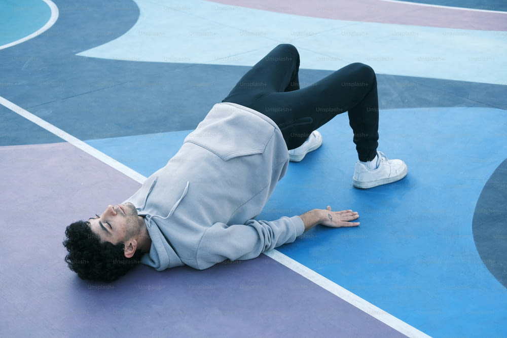 a man laying on his back on a basketball court