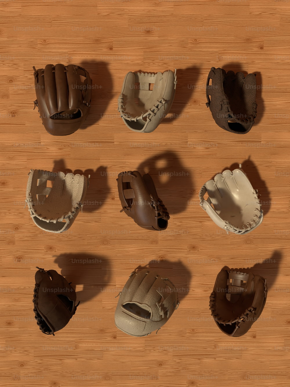 Eine Gruppe Baseballhandschuhe sitzt auf einem Holzboden