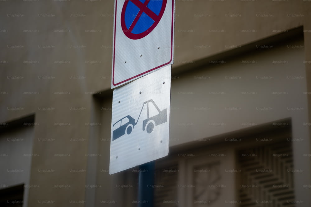 una señal de no estacionamiento en un poste al lado de un edificio