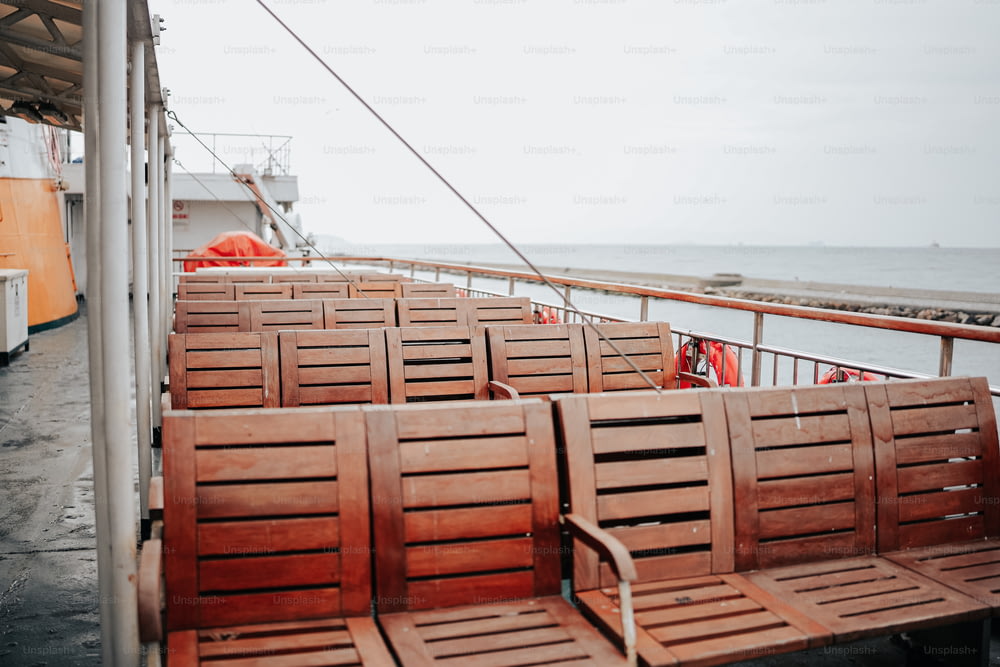 a row of wooden chairs sitting on top of a boat