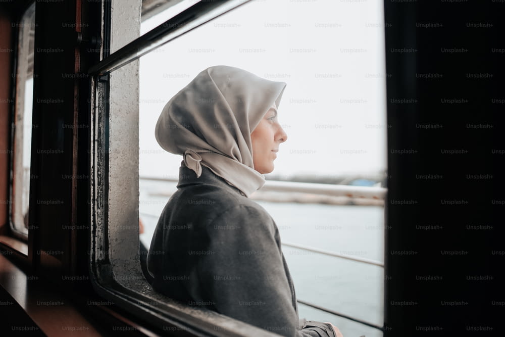 Une femme regardant l’eau par la fenêtre
