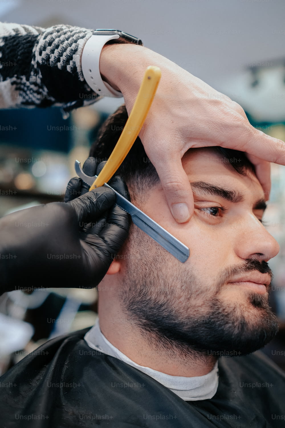 a man cutting another mans hair with a pair of scissors