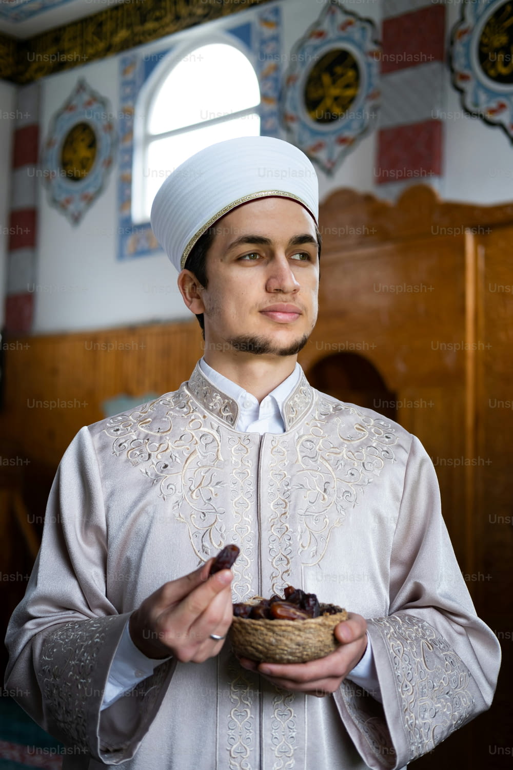 a man in a white outfit holding a bowl of food