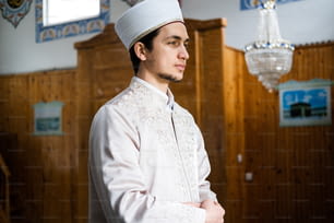 a man in a white outfit standing in a room
