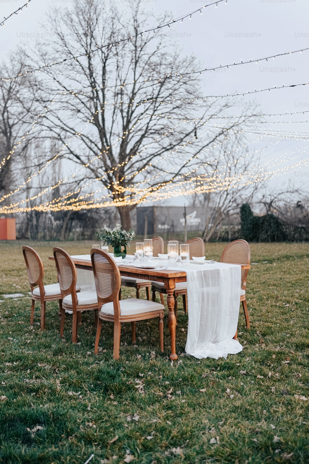 a table set up for a formal dinner in a field