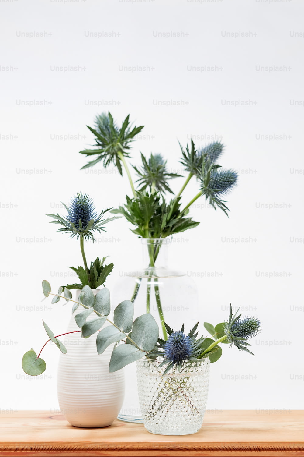 um par de vasos cheios de plantas em cima de uma mesa