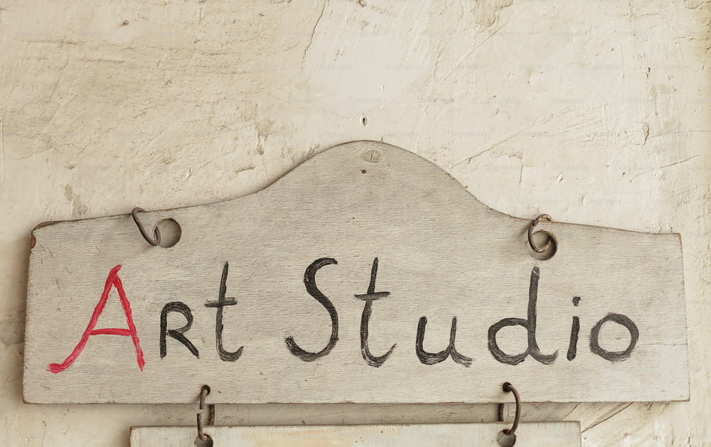 a sign that says art studio hanging on a wall
