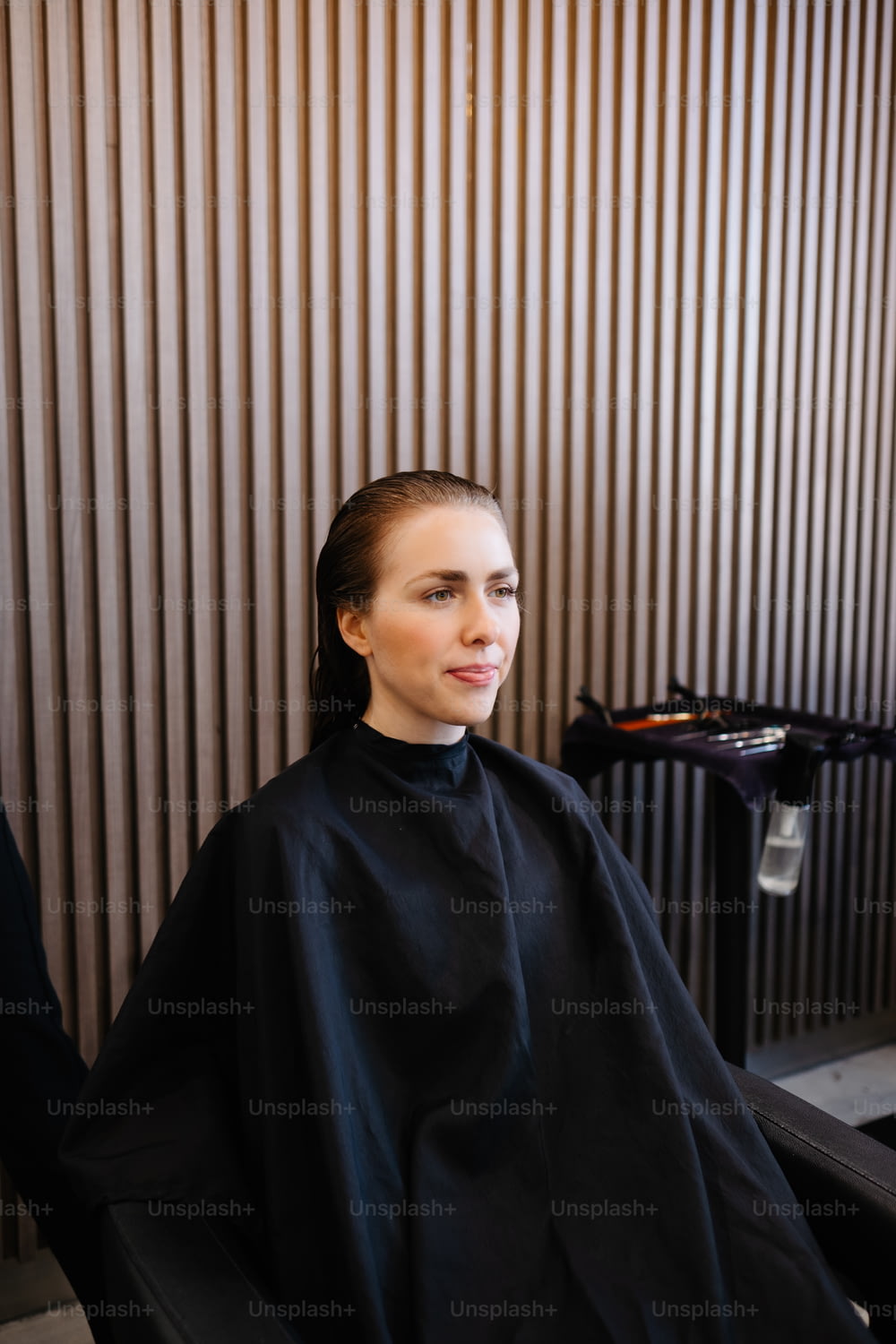 a woman sitting in a chair getting her hair cut