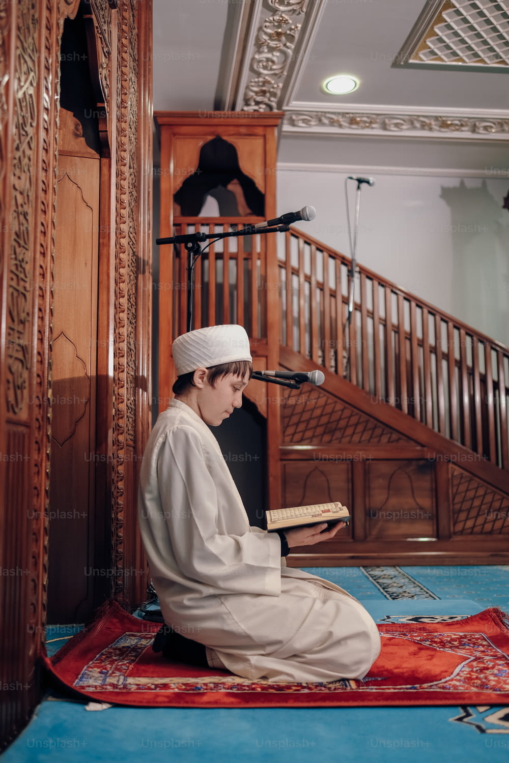 a person sitting on a rug reading a book