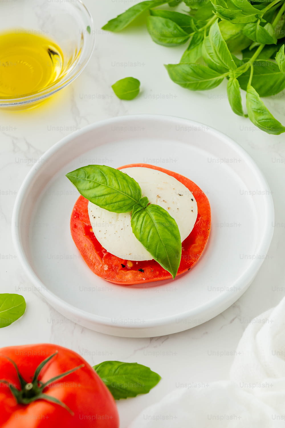 a white plate topped with a tomato and cheese