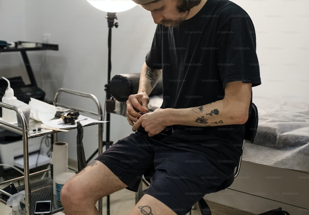 Ein Mann mit einem Tattoo sitzt auf einem Stuhl