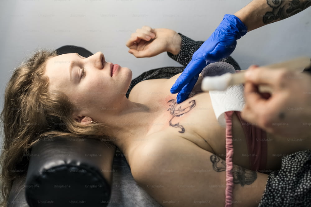 Una mujer haciéndose un tatuaje hecho por un artista del tatuaje