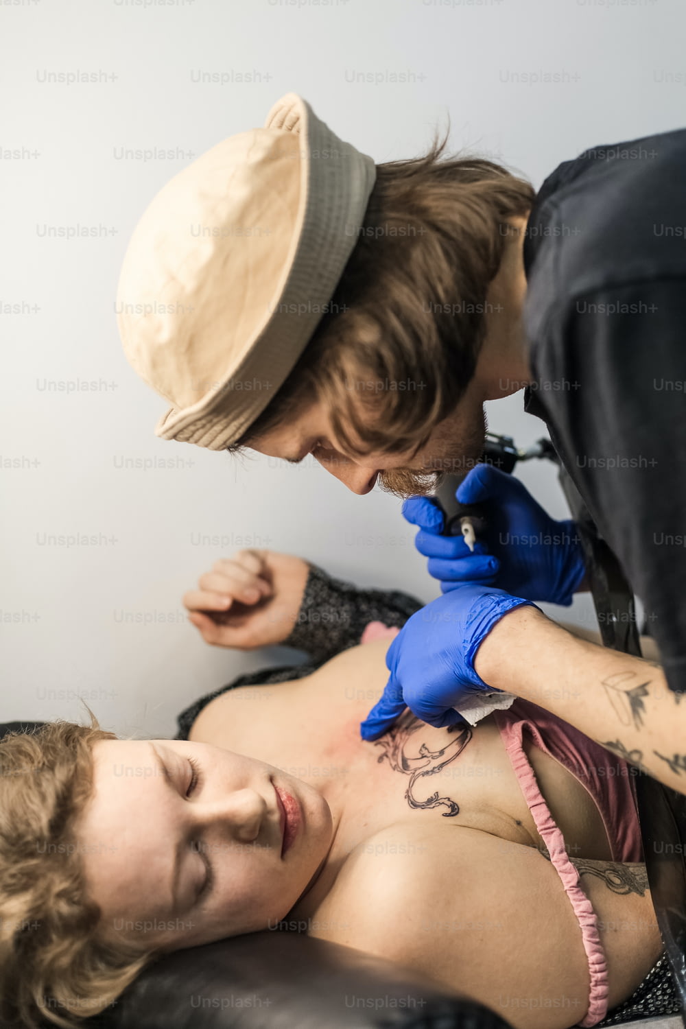 una donna che si fa un tatuaggio fatto da un tatuatore