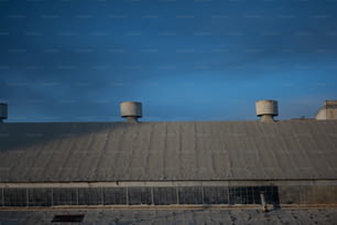 the roof of a building with three water tanks on top