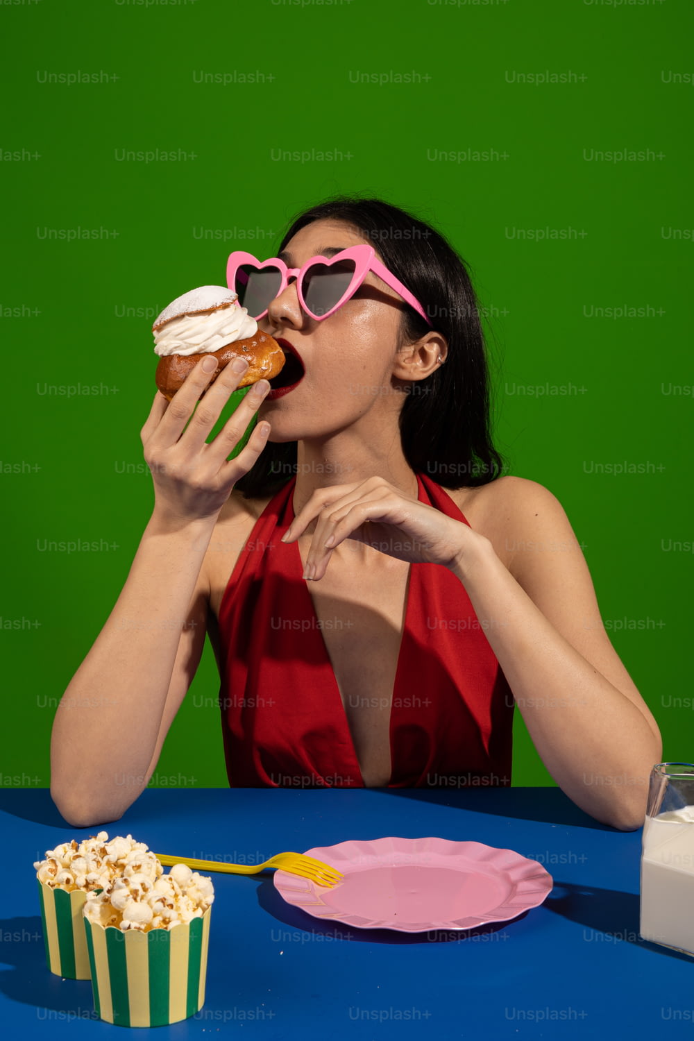 a woman in a red dress eating a cupcake