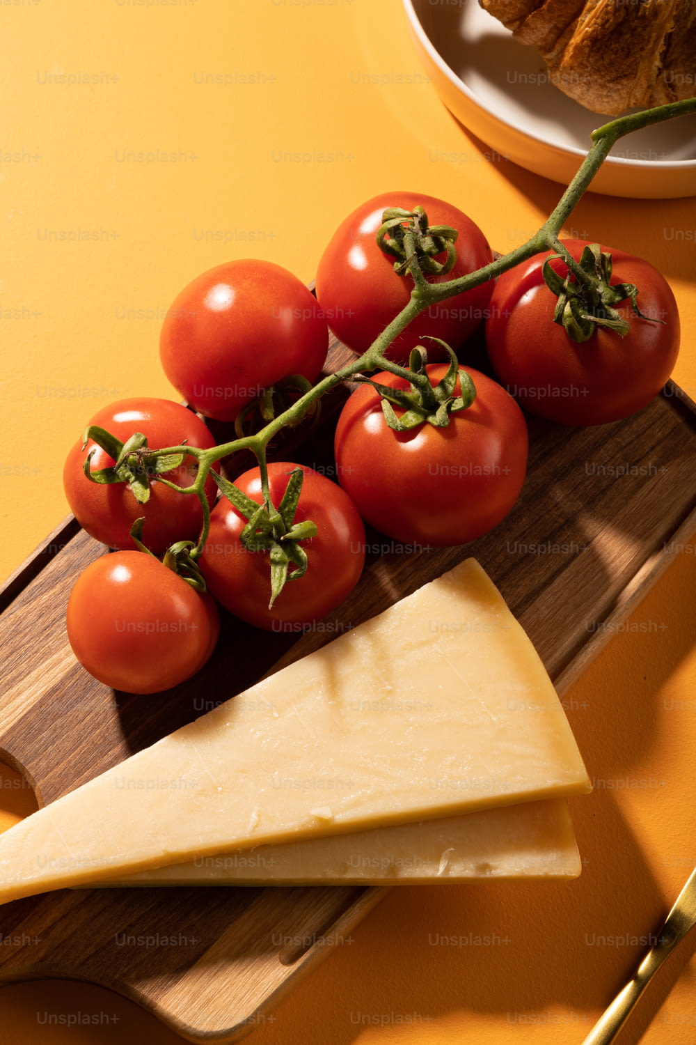 une planche à découper en bois garnie de tomates et de fromage