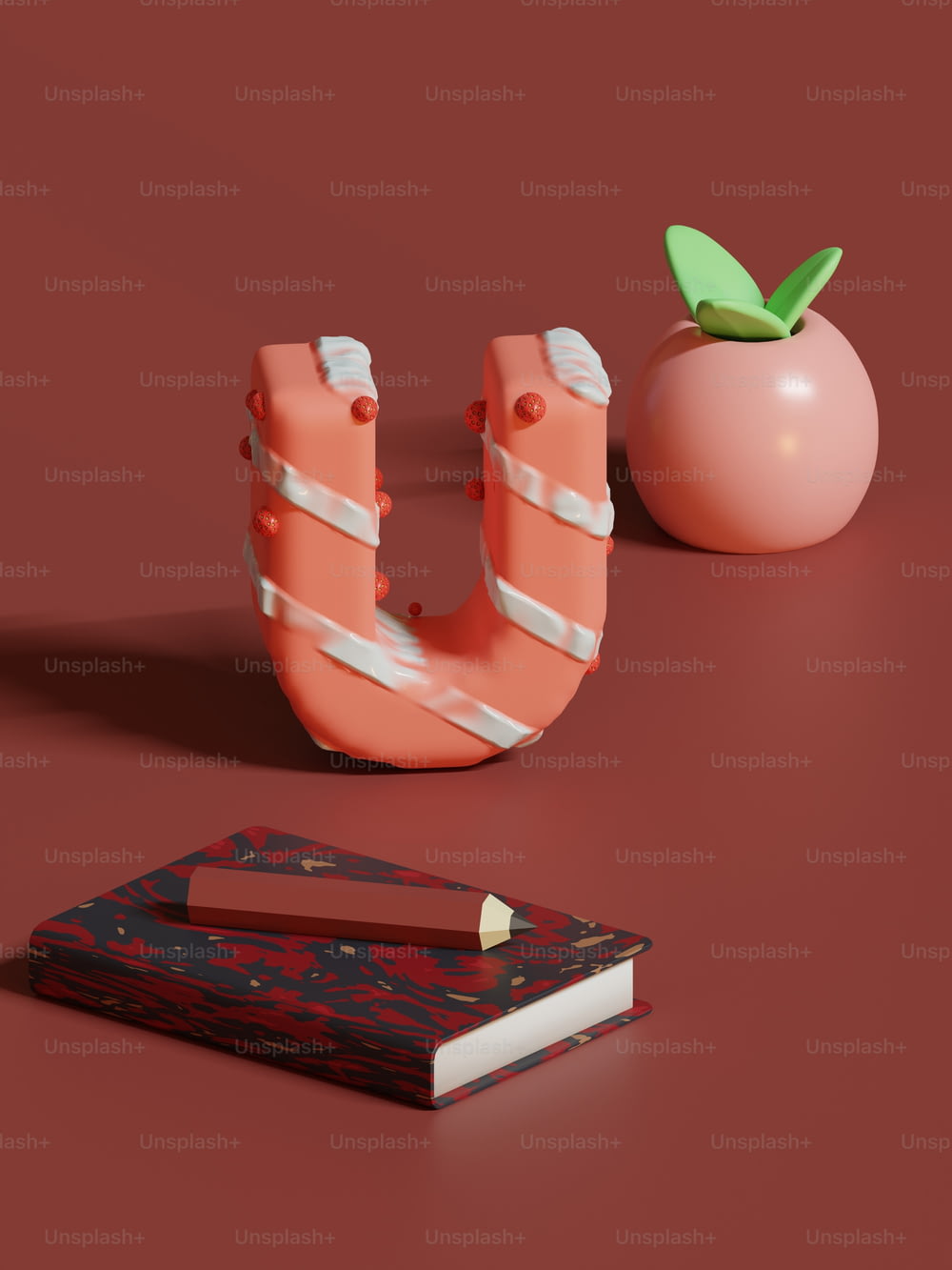 a book, a tomato, and a pair of scissors on a red surface