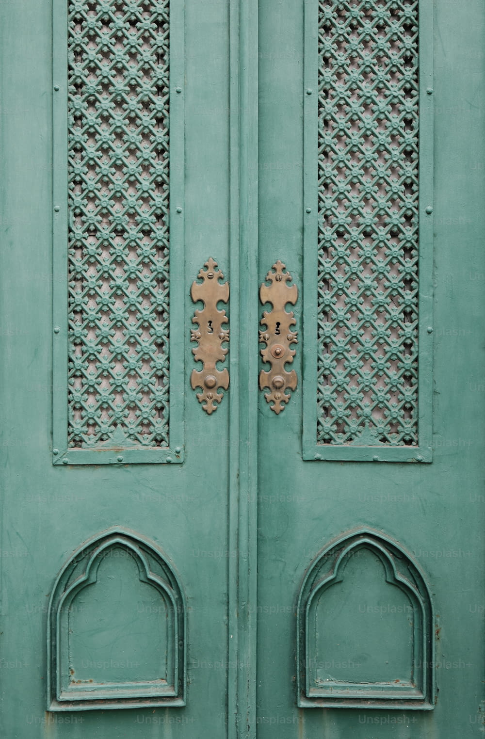 Un primer plano de una puerta verde con diseños ornamentados