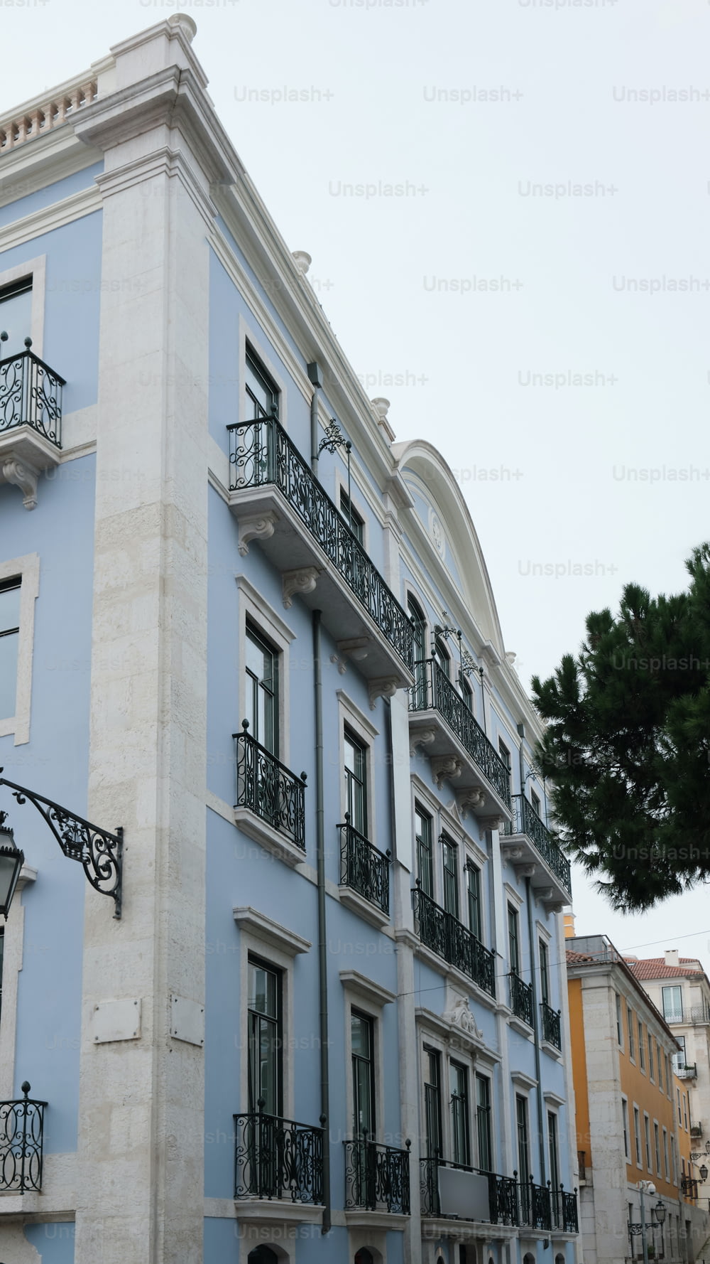 a blue and white building with balconies and wrought iron balconies