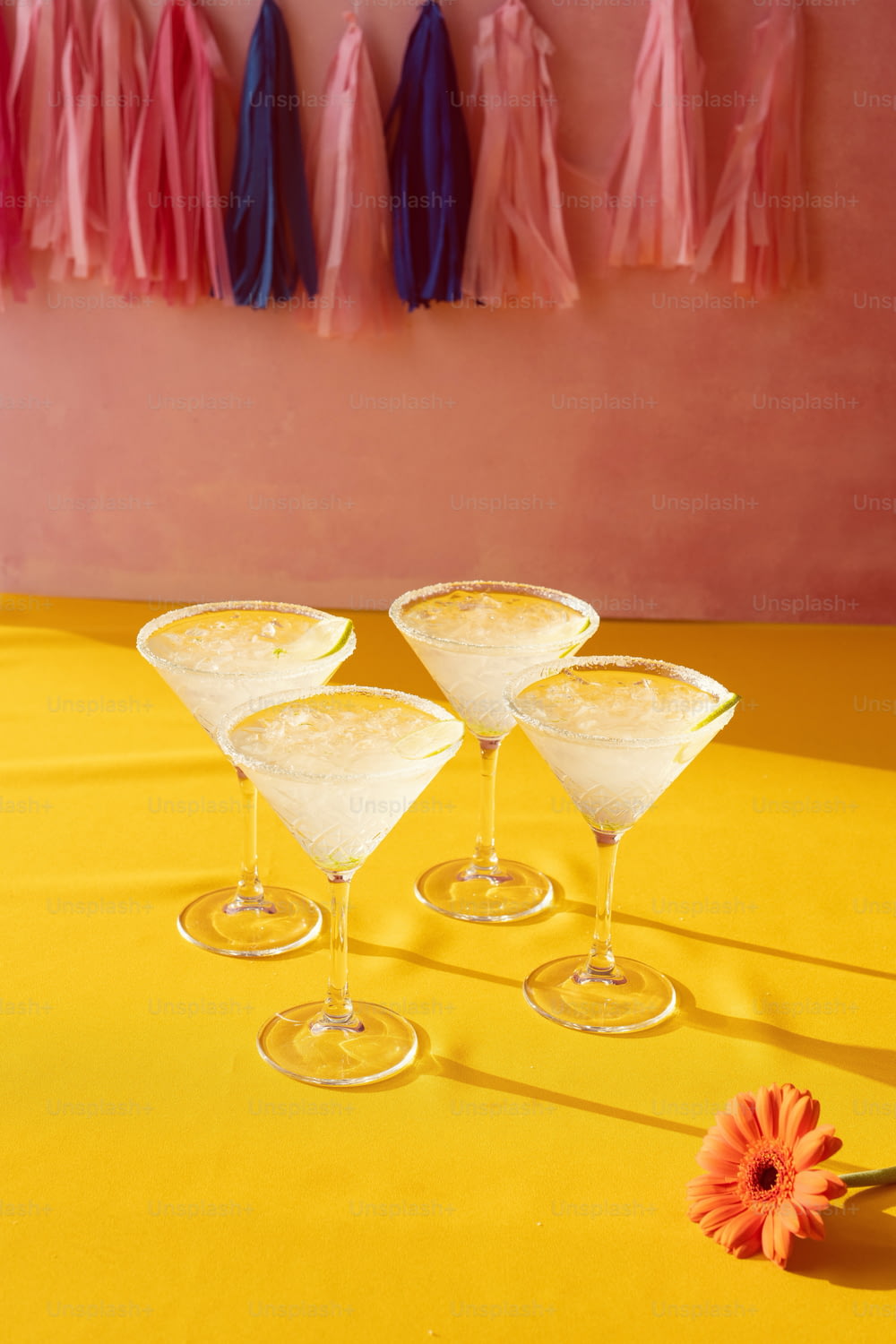 three martini glasses sitting on top of a yellow table