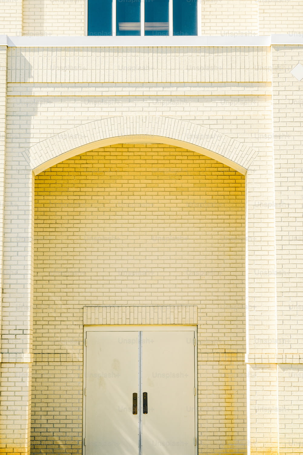Un par de puertas blancas sentadas frente a un edificio