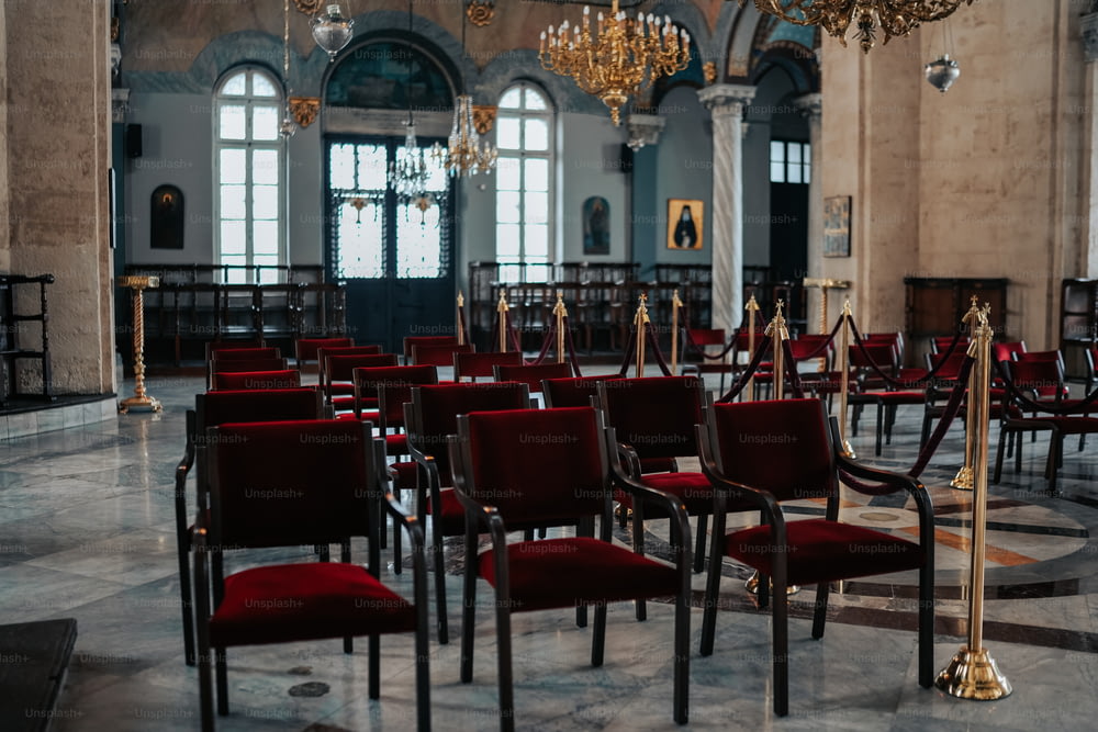 Ein Raum voller roter Stühle und Kronleuchter