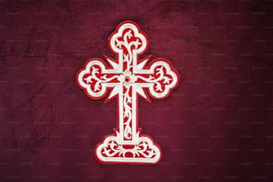 uma cruz vermelha e branca em um fundo vermelho