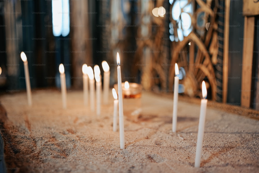 um monte de velas brancas que estão em uma mesa