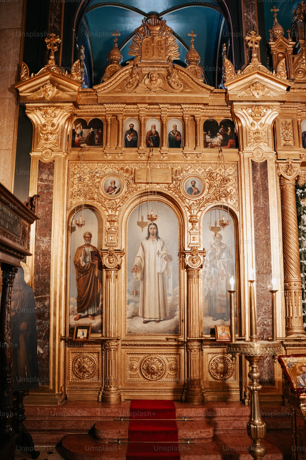 um altar da igreja com uma pintura de uma mulher e dois homens