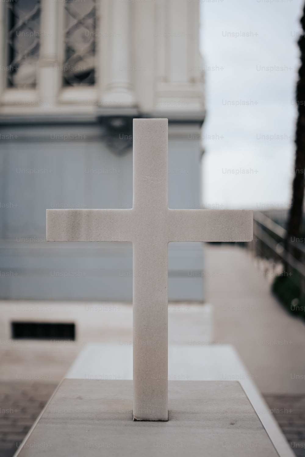 une croix blanche posée sur une dalle de ciment