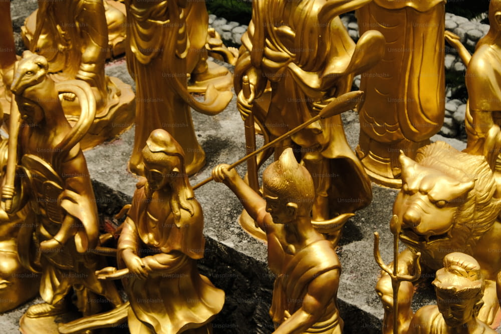 Un gruppo di statue d'oro sedute in cima a un pavimento di pietra