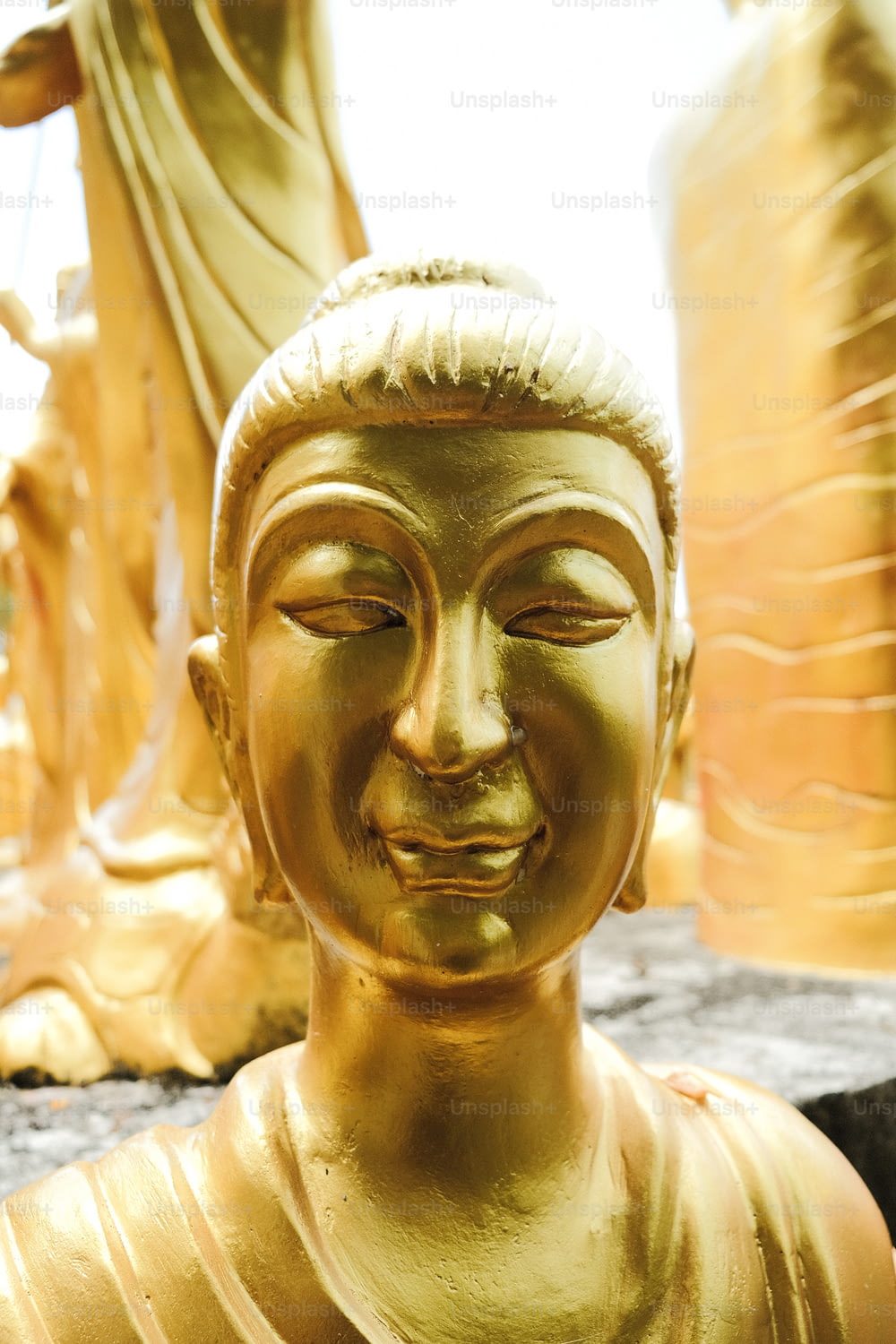 a golden buddha statue sitting in front of other buddha statues