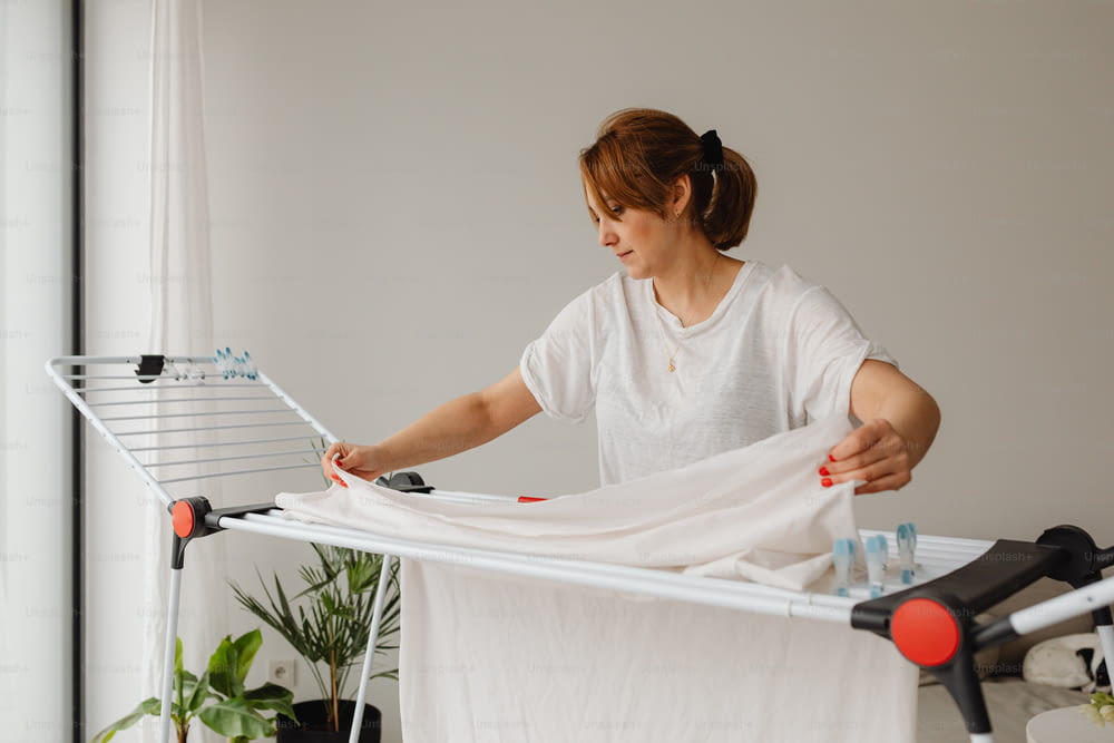 Eine Frau bügelt Kleidung auf einem Bügelbrett