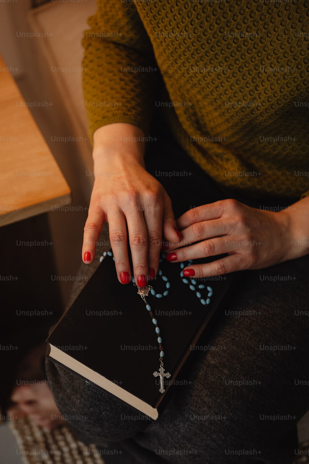 Una donna tiene in mano un rosario e un libro