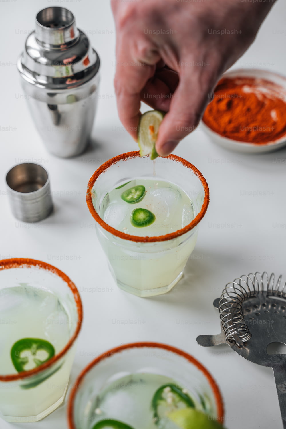 a person dipping a lime into a margarita