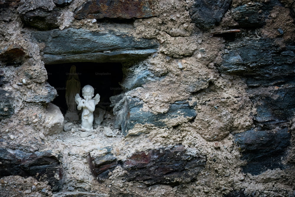 uma pequena estátua de um anjo em uma caverna