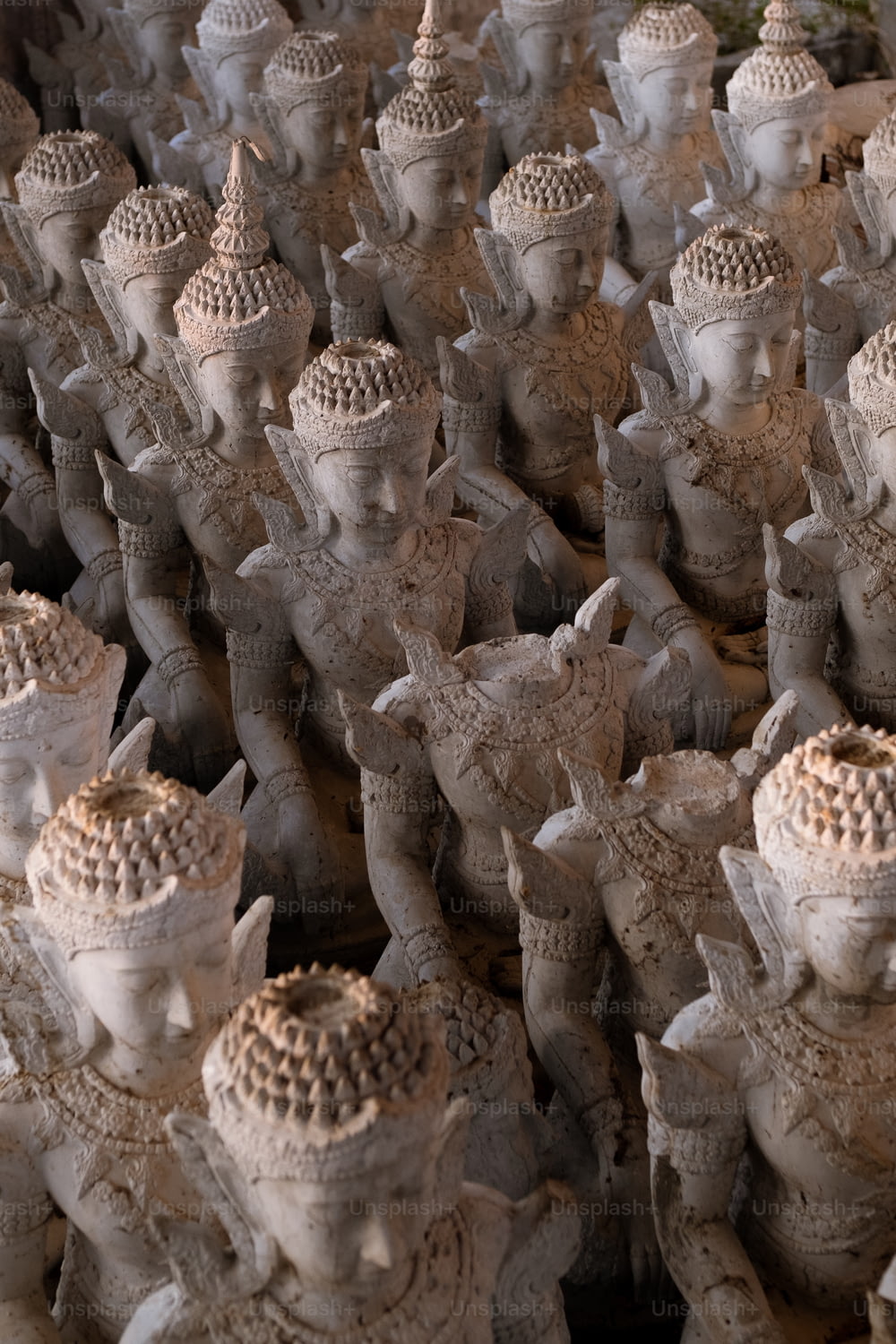 a large group of statues of elephants and men