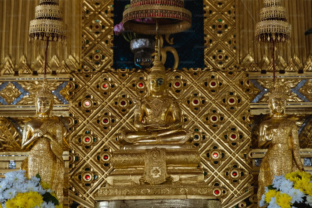a golden shrine with a buddha statue and flowers