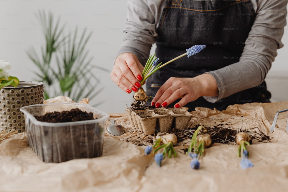 a woman is arranging flowers in pots on a table