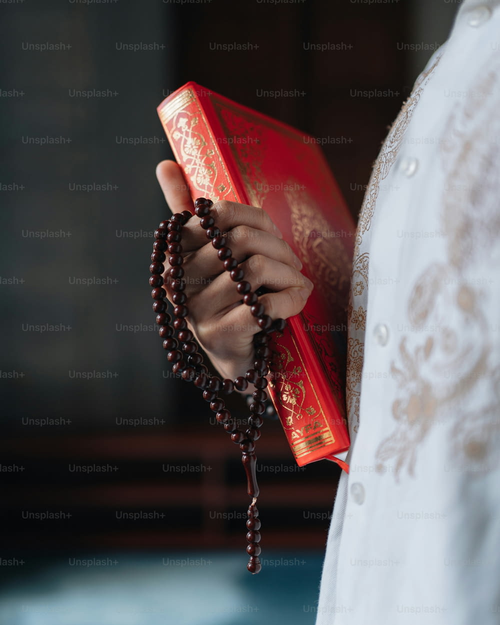 una persona che tiene in mano un rosario e un libro