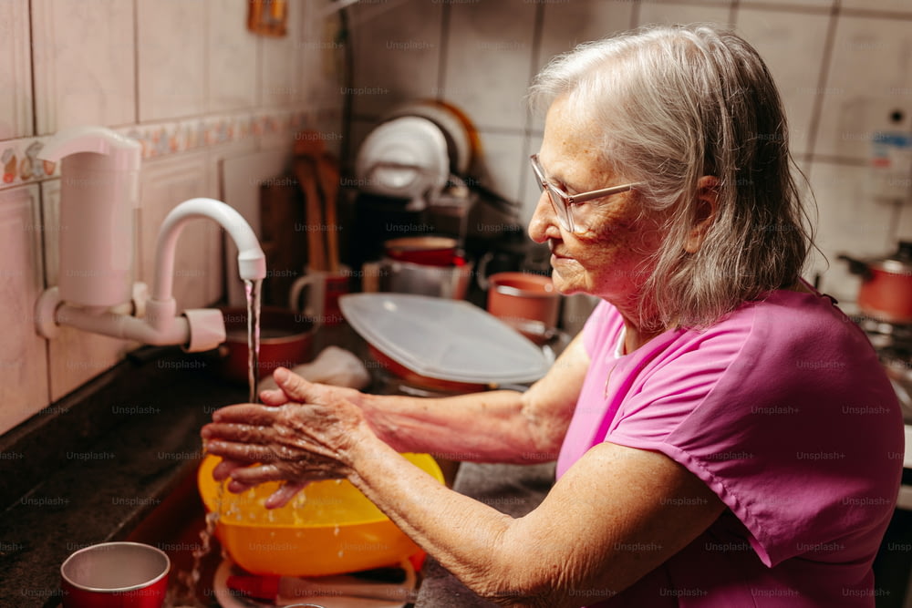 a woman washing her hands in a sink